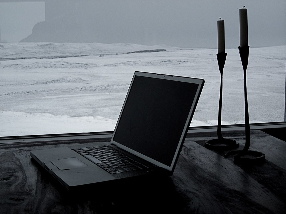 a laptop in front of a winter background with two candles