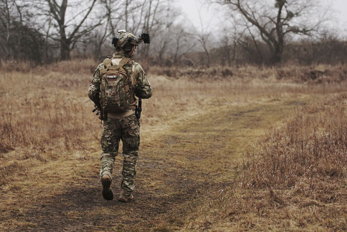 A soldier walks down a rough path 