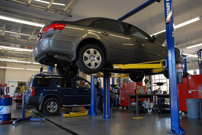 Interior image of an auto repair shop with vehicles being repaired
